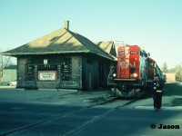 Spring has sprung as CN GP9RM 4132 leads the 15:30 Kitchener Job through downtown Waterloo, Ontario on the Waterloo Spur as the crew prepares to protect Regina Street. The job has three hoppers for Nutrite in Elmira. 