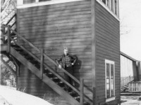 <b> Signalman and Tower </b> <br>
The Signalman stands on the stairs leading to the CPR Interlocking Tower at Mile 13.9 Milton Subdivision. CNR Interlocking Signals were controlled by the Signalman from this tower located on the south west quadrant of the Railway Crossing at Grade.