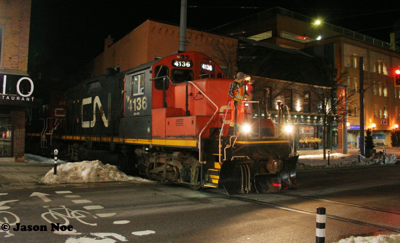 CN L566 with 4136 and 9450 slowly eases across King Street in downtown Waterloo, Ontario as they head to Elmira on the Waterloo Spur.