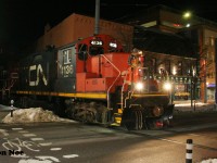 CN L566 with 4136 and 9450 slowly eases across King Street in downtown Waterloo, Ontario as they head to Elmira on the Waterloo Spur.