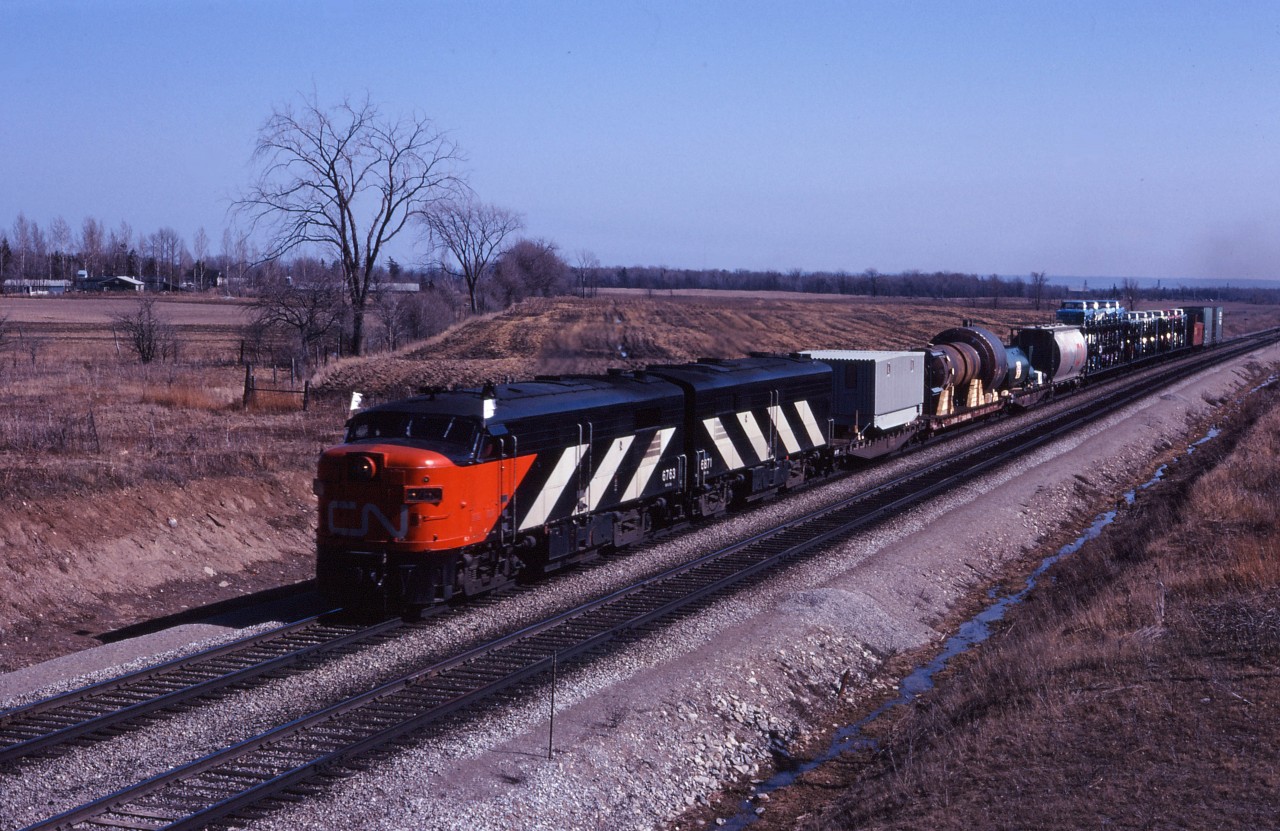 Passenger units 6763 and 6871 lead a short eastbound towards Tansley in the spring of 1970. "High and Wide" loads and auto cars make up most of this short train (8 cars and the van).