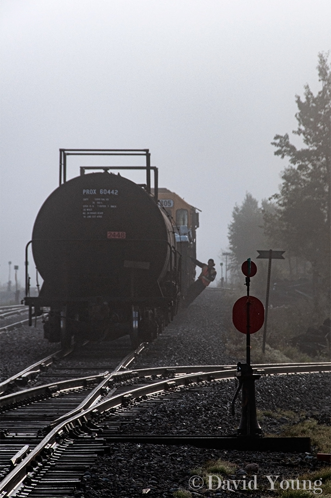 A cool, foggy morning at Kidd, finds the recently arrived crew of Ontario Northland 207 in the midst of working the yard at Kidd. The conductor hangs off a gondola of ore concentrate, guiding his engineer into the joint with a lone tank car left on the main. Once together he will line the north wye switch normal before guiding the movement another four miles further down the line to switch the Ineos Calabrian plant.