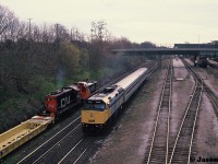 During a slightly overcast spring morning, VIA Rail train 92 powered by 6428 passes a CN job switching Stuart Street Yard in Hamilton on the Grimsby Subdivision. CN 1355 and 7101 were sorting newly built DTTX container cars manufactured at the nearby National Steel Car facility. 