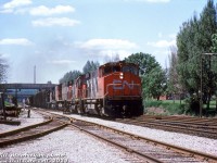 CN M420 2546, C424 3218 (with a really saggy frame), M420 2504, GP40-2L(W) 9522, and S7 8226 head up freight #431, having just finished working <a href=http://www.railpictures.ca/?attachment_id=31509><b>Stuart Street Yard </b></a>and now on the move eastbound through Hamilton on the Oakville Sub (timetable west) just transitioning to the Grimsby Sub (timetable east) at the old James Street Station site in the distance. The train is seen passing under Mary Street, John Street and James Street bridges, and passing by the old junction point around Mile 43.6 where the <a href=http://www.railpictures.ca/?attachment_id=37312><b>Hagersville Sub</b></a> branched off to the south at Ferguson Avenue (gone today), and the <a href=http://www.railpictures.ca/?attachment_id=5764><b>N&NW spur</b></a> to the north into the industrial district.
<br><br>
<i>Bill McArthur photo, Dan Dell'Unto collection slide.</i>