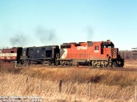 CP GP35 5002, ALCO RS27 901 and CP FPA2 4083 handle a freight on the Belleville Sub at Darlington ON, passing a barren late fall landscape sometime in November or December 1971. The exact location is not noted, but it appears to be eastbound at Baseline Road at the east end of Darlington siding.<br><br>ALCO 901 was originally one of four RS27 units built for the C&NW, who traded them back to ALCO after a few years for new C425's. ALCO then painted them black, and leased two (900-901) to CP in the early 1970's. While on lease, they changed hands to Precision Engineering Co (PECO), and then Precision National Corp (PNC), still on lease to CP. 901 later ended up on the Minnesota Commercial as their 318 (now stored), and sister 900 on Peabody Coal (since scrapped).<br><br>CP 5002 was CP's first GP35 (numbered above the two GP30 units, and originally delivered as CP 8202). It would eventually become CP control cab/slug 1126. The 4083 trailing, one of CP's freight-passenger FPA2 units, would catch fire the next year and be retired.<br><br><i>Keith Hansen photo, Dan Dell'Unto collection slide.</i>