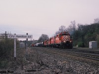 During a spring morning, CP GP9u 8209, RS18u 1831 and another RS18u and GP9u are viewed leading a train onto the CN Oakville Subdivision at Hamilton Junction after having departed CP Aberdeen yard in Hamilton, Ontario. The train will continue eastbound to Toronto over the Oakville Subdivision before reaching CP trackage again at Canpa.