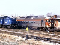 CP Rail RDC-2 9115 and another car are stopped by the station at Fort Erie, handling today's Toronto-Buffalo (ex-CP/TH&B/PC) RDC run now under operation by VIA Rail (some of the ex-CP Budds weren't yet repainted, and operated in full CP paint in early VIA years. They were also maintained by CP shop forces out of John Street roundhouse in Toronto). The train was in its final months of operation, and would be <a href=http://www.railpictures.ca/?attachment_id=9031><b>discontinued in April 1981</b></a> in favour of the new <a href=http://www.railpictures.ca/?attachment_id=41208><b>Amtrak Maple Leaf</b></a>.<br><br>On the next track over, Conrail SW1500 9570 and an unknown GP35 operate on a US-Canada transfer run, likely about to return across the <a href=http://www.railpictures.ca/?attachment_id=41386><b>International Bridge</b></a> into the US.<br><br><i>Robert Kentie photo, Dan Dell'Unto collection slide.</i>