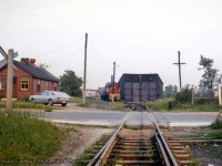 Taking a step across Alice Street from <a href=https://www.railpictures.ca/?attachment_id=54355>last week's posting,</a> a wider view of the CPR Guelph engine house facilities on the Fibreglass Spur in Guelph.  CPR MLW S11 6617 is assigned as the Guelph yard engine.

<br><br>As mentioned in previous comments by retired CPR conductor, Ron Bowman, the CPR structure at left was sold for use as a private residence, now located at 28 Sackville Street, just a little way behind the photographer around the wye.



<br><br><i>Donald Coulman Photo, Jacob Patterson Collection Slide.</i>
