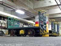 Not somewhere you'd have access to on a normal tour of Toronto Union Station:
<br><br>
Buried under the bustling platforms and station concourses, down amid the underground tunnels, access corridors and parking garages, was the maintenance area for VIA Rail's fleet of ancient electric battery-powered baggage carts that served their trains arriving and departing Union Station. A full house of green and blue carts sit parked in their bays, while the walls are lined with charging outlets, power cables, and spare parts. More modern equipment including a small forklift and pull-tractor sit nearby out-of-frame. When in use, the carts could be found stationed empty on the platforms upstairs awaiting an incoming train, or fully loaded up to their top bars with luggage bags, suitcases, duffle bags and other large pieces of travel baggage.
<br><br>
According to the Toronto Railway Historical Association's website, the old electric battery powered baggage carts were built in the 1920's by the Elwell Parker Electric Company for use at Union Station when it was brand new. They were pedal and lever-operated, and could be controlled from either end by a baggage handler. One of the green carts would later be donated by VIA Rail to the TRHA in 2014 (judging by spotting features, it may be the second one in). It's unlikely any of the others remain in operation today, replaced by more modern equipment.
<br><br>
The rare-access weekend Union Station tour that included a visit to the unused upper offices of Union Station, the underground corridors, and a tour of the shuttered ex-CPR John St. Roundhouse (before the museum opened, and before much of the then-untouched roundhouse was converted to house Leons) was courtesy the Toronto Railway Historical Association, organized for the visiting Guelph Historical Railway Association, and guided by the late Toronto railway historian Derek Boles (who was a wealth of knowledge, and known for his numerous published historical railway articles and regular Union Station tours). A number of RP.ca contributors were also in attendance that day.