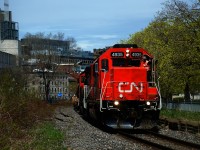 A crewmember gives the peace sign as CN 500 leaves the Port of Montreal with a single hopper followed by baretables.