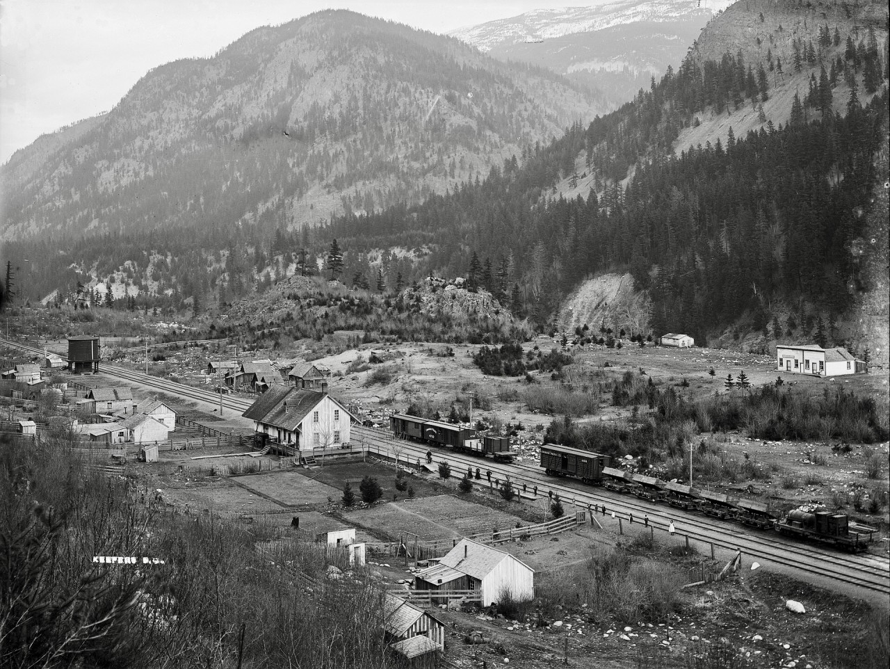 By an amazing stroke of luck during research of CP construction-era history in BC, an 1890s Archibald Murchie 8.5” x 6.5” glass plate negative of Keefers was discovered (on a UK site!) for sale, and purchased, then scanned professionally at 3200 dpi.  You may have seen on-line images (example:   https://dx.doi.org/10.14288/1.0422676) of prints of that, but this is the original, with far more detail than shown in those prints.

Higher resolution versions are readily available on request, and I plan to present an example of the high level of detail available from that negative very soon — counting the chickens in front of the distant building on the far right is easily possible!  The work of earlier photographers, with equipment far bulkier and awkward to transport than the 35 mm and 6x7 cm medium format cameras with which I am familiar, is strongly appreciated here, and their style of seeking elevated perches to capture railway scenes influenced many of my own many-years-later attempts.

For more information about the CP construction era in western British Columbia, I suggest https://web.archive.org/web/20071023172207/http://www.kag.bc.ca/Exhibitions/AllAboard/allaboard.html (”rabbit hole” warning!), particularly the Contract No. 61 section, which is an archived copy of Kamloops Art Gallery‘s presentation ‘Onderdonk’s Way’, a magnificent collection of historical images and data.