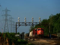CN 321 is passing under a vintage signal bridge as it prepares to do a tail end lift at Coteau. Work has already begun on replacing the various signals around Coteau, including this one.