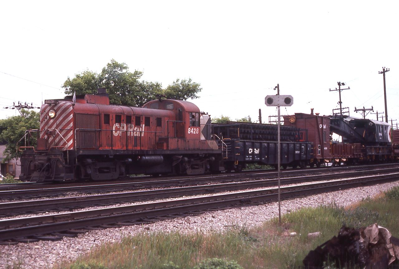 As I headed into CP's Agincourt Yard on Sunday June 5th, 1977, to see what there might be of interest, this auxiliary train with the 8428 was heading west.  Found the train near the west end of Lambton Yard as they were preparing to rerail a couple of wayward cars that had left the rails.