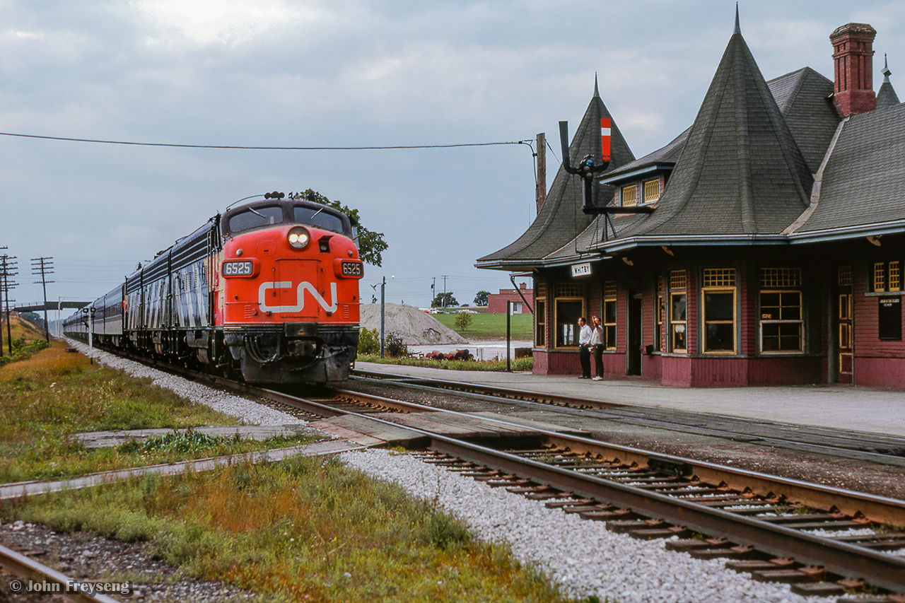 CN Rapido 64 passes through Whitby ducking under Henry Street near the 1912-built station.  Passenger service to this station ended in 1969, with it being relocated in 1970 by a group of local artists to the corner of Henry and Victoria Streets, just south of its original location.  In 2004 it would be moved again, just across the street where it remains today.

Scan and editing by Jacob Patterson.