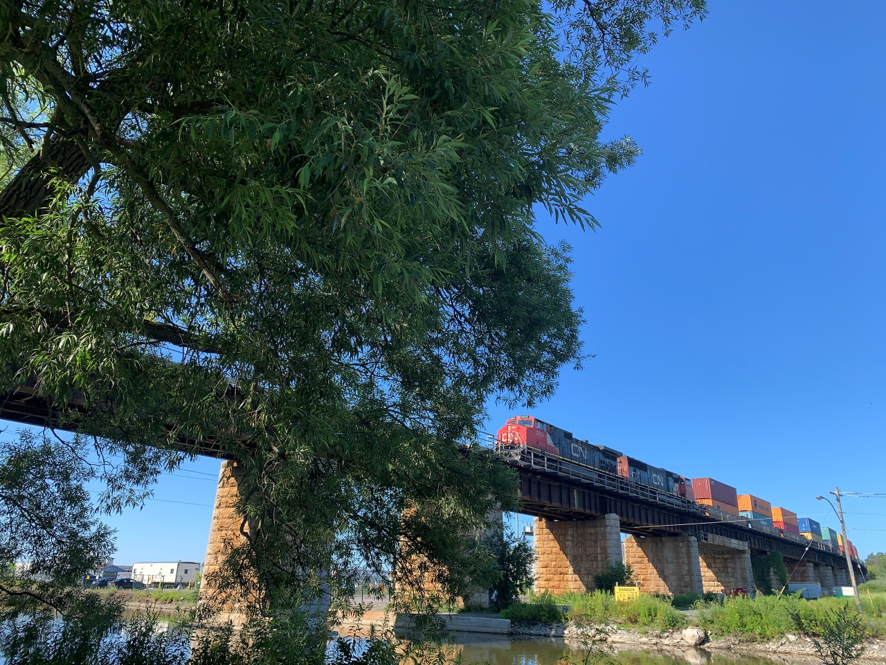 CN 2550 (GE C44-9W) and 5700 (EMD SD75I), both representing CN's late 1990's power investments, lead a handsome stack of intermodal containers across the storied Port Hope viaduct. 

Always a treat when you catch two locomotives still sporting pre-website logos!