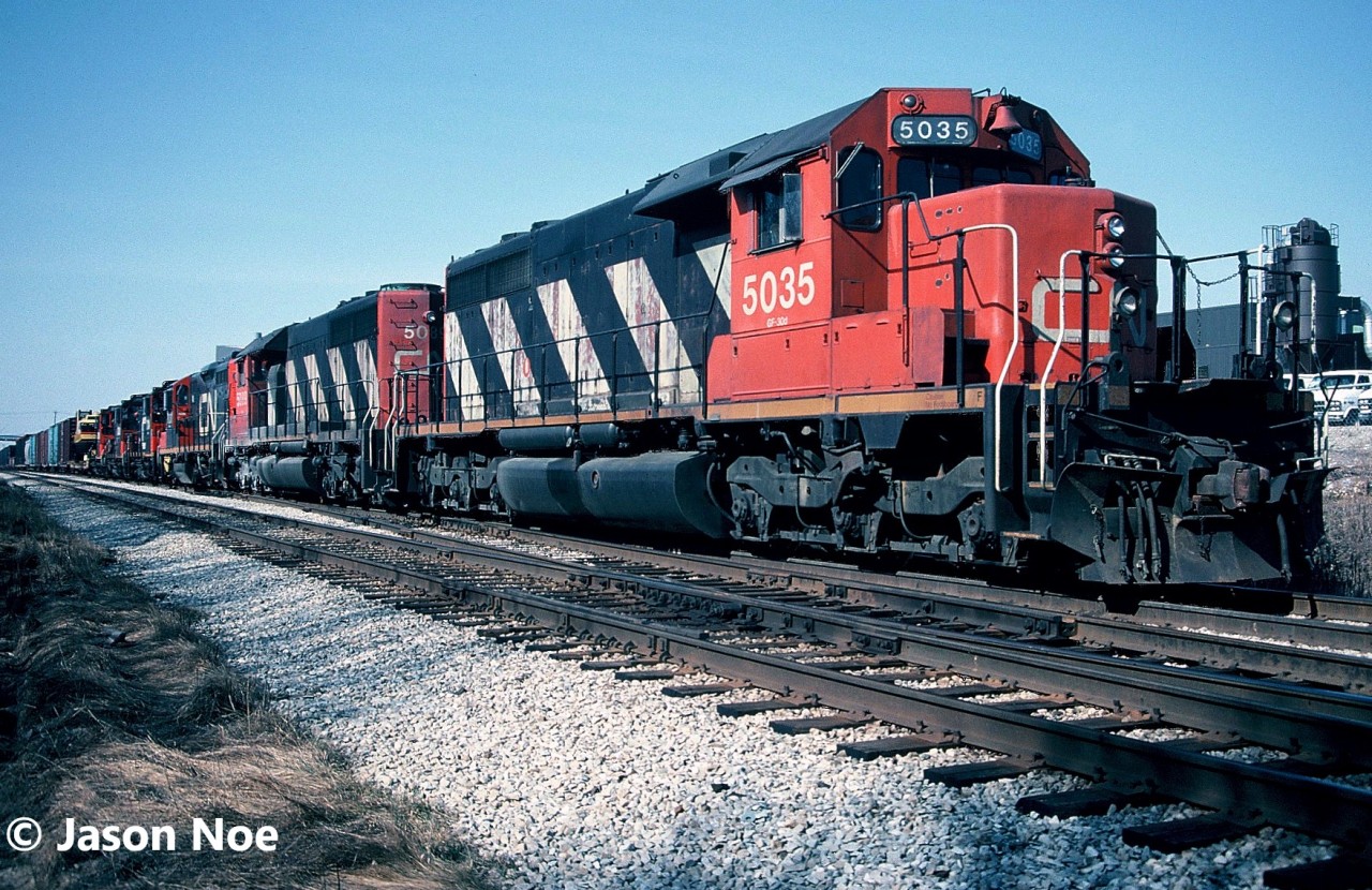CN train 422 sits in the siding at Kitchener, Ontario on the Guelph Subdivision waiting on a new crew with quite the consist. It included; SD40’s 5035, 5089, GP9RM 7031, SW1200RSm’s 7309, 7314 and 7104. All the four-axle units were lifted at London for the trip back to MacMillan Yard. Thankfully at the time, I was on my March break from high school and was able to get some photos, as 422 typically went east through Kitchener during the night or early morning hours.