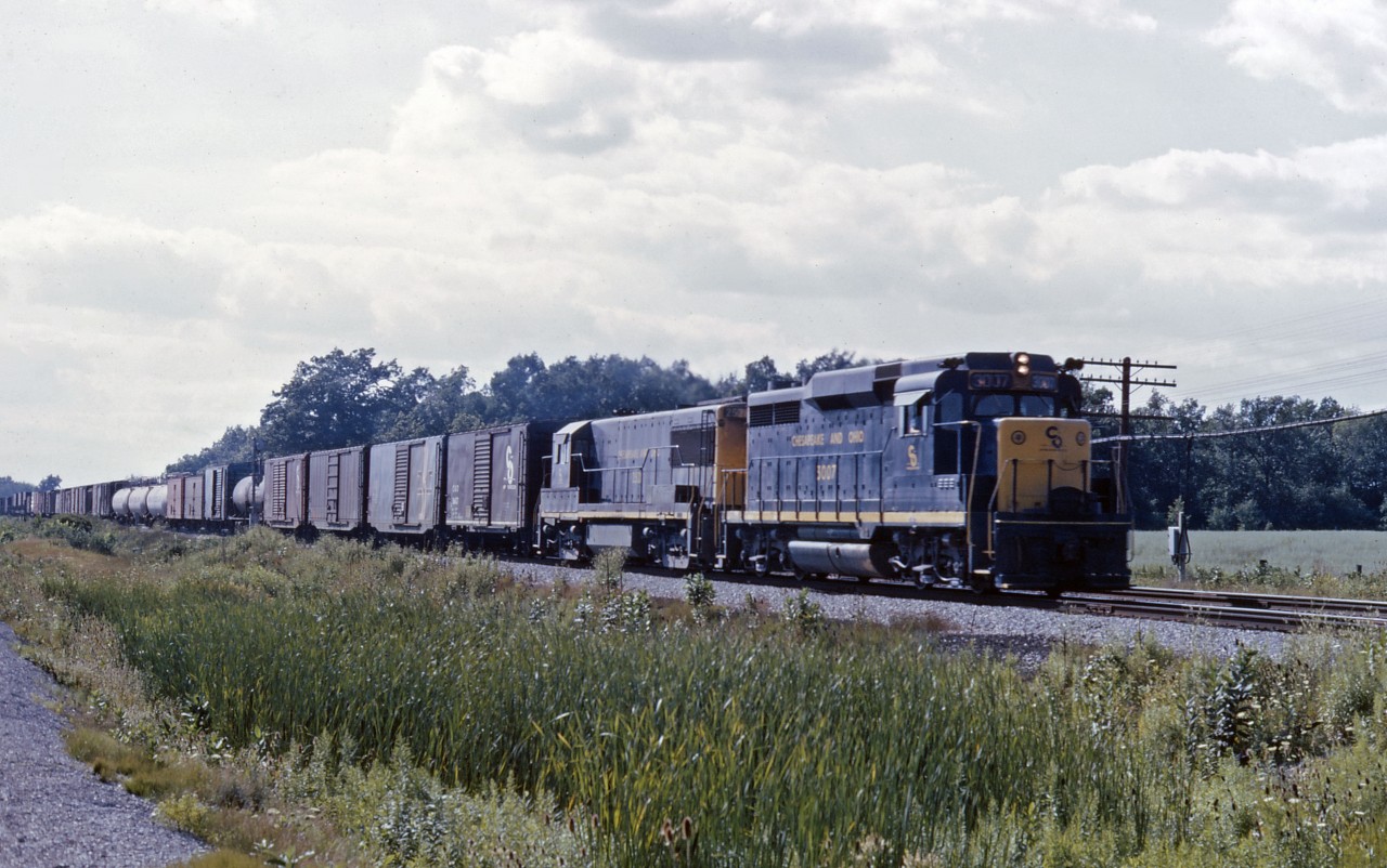 As is so typical of a southern Ontario summer day, early afternoon clouds are building as a C&O eastbound races through Canfield behind GP30 3007 and U25 257?. Hopefully there won't be rain this afternoon to spoil the day of train-watching at one of my favourite locations...