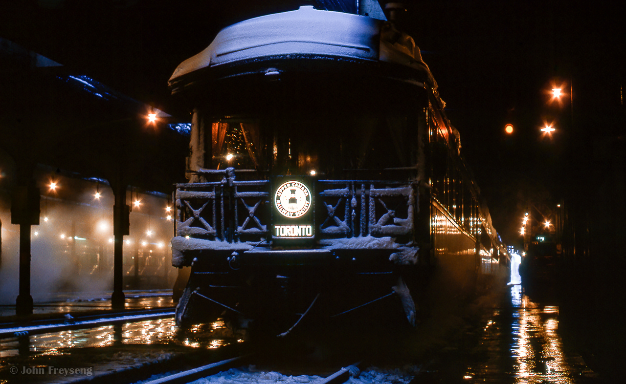 Bathed in the warm lights of the trainshed at Union Station, the early morning hours find the Upper Canada Railway Society's private car, Nova Scotia, on the tail end of a UCRS excursion, departing later that morning for Paris via Hamilton and Caledonia.

Originally constructed in 1896 for the Windsor & Annapolis Railway as parlour car, Sanspareil, the car would become Dominion Atlantic Railway business car, Nova Scotia, in 1912, and later to Canadian Pacific Superintendent's Car 7 in 1956.  The car would be acquired by the Upper Canada Railway Society in 1963, assuming its Nova Scotia identity, until being sold to the London Middlesex Historical Society in 1969.  Nova Scotia would be sold to the Ossawippi Express Diner near Orillia in 1970, before returning to Toronto in 2012, now preserved in the former CPR John Street roundhouse.

Scan and editing by Jacob Patterson.