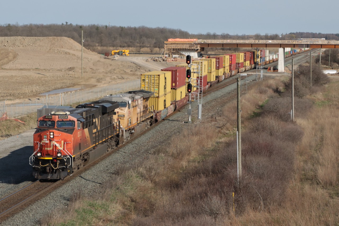 With no assistance being provided by UP 6596, Q148 labours up the grade at 11 mph, previous attempts to restart UP 6596 were unsuccessful. The bridge under construction will provide access from Britannia Road to the CN Milton Logistics Hub facility.
