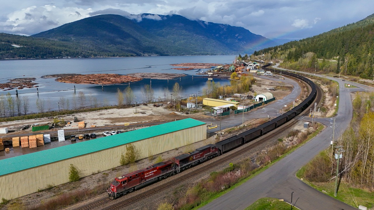 After a brief storm, the sun is shining once again and produced a rainbow, just as CPKC 805-188 snakes through Canoe, BC on the shores of Shuswap Lake.