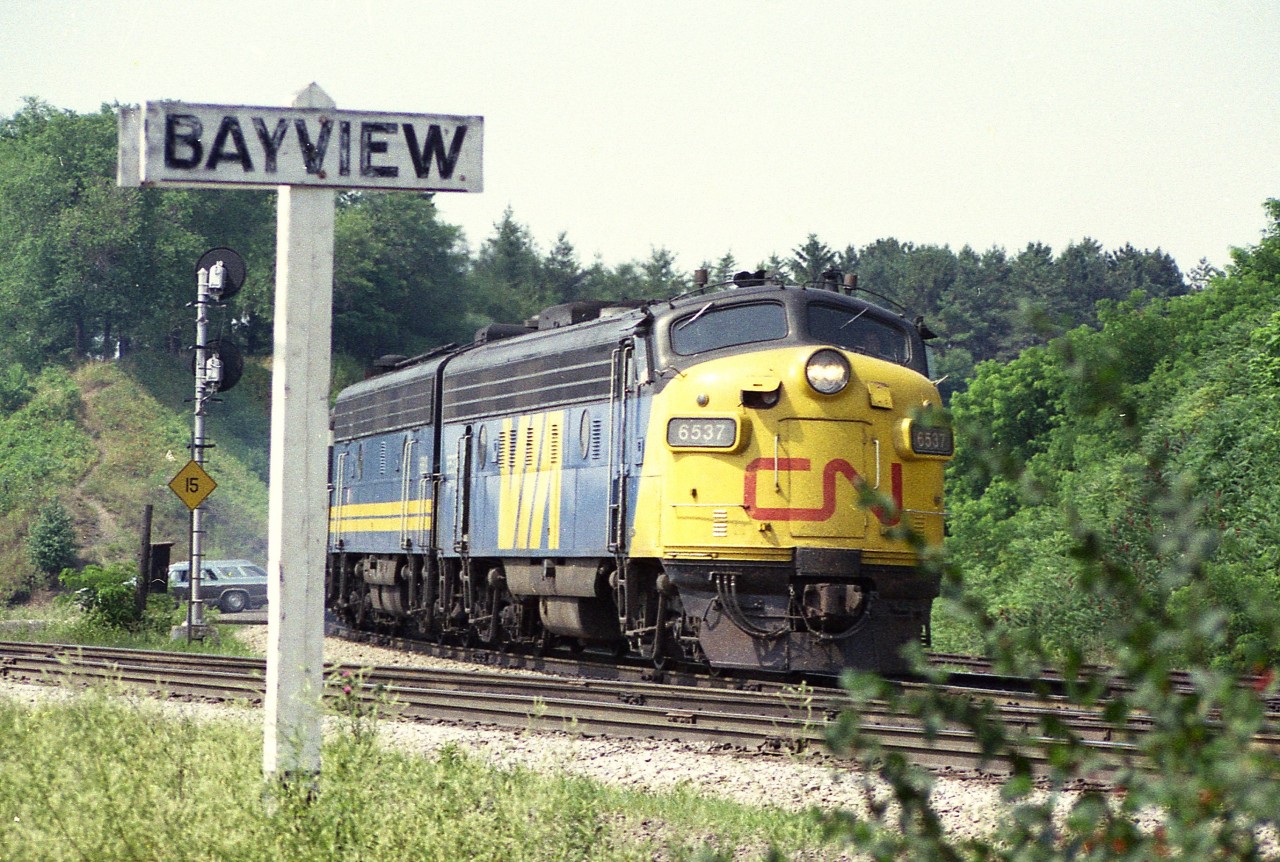 Close grab shot of CN 6537 and unknown B unit as the train drifted around the bend and caught me off guard, probably with my mind drifting off as well.
The old wooden Bayview sign was replaced a long time ago.  I liked the early VIA scheme with the red 'CN' on the nose. The variety on the snout of the cab units, either 'CN', "VIA' or 'plain'  made for interesting captures.