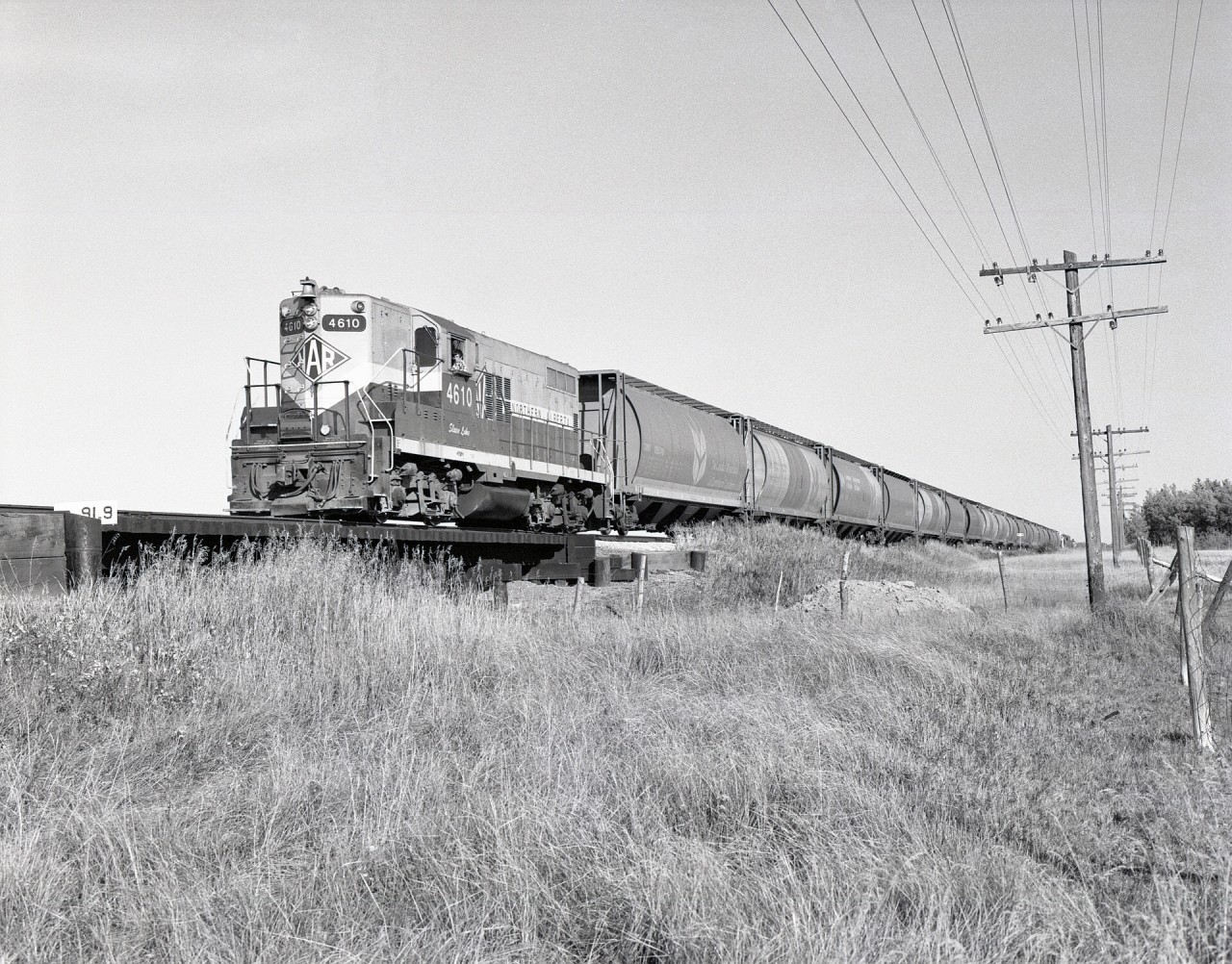 When CN took over Northern Alberta Railways on 1981-01-01, not much changed visually at first, with locomotives renumbered into the CN plan but other markings left intact.  On Tuesday 1981-09-15 at 1710 MDT, CN 4610 (ex NAR 209) ‘Slave Lake’ led a wayfreight from Grande Prairie to Dawson Creek westward from Hythe over a little bridge crossing a nameless (as far as I can determine) squiggly little creek at mileage 91.9, halfway between Range Roads 113 and 114.

One appreciated characteristic along the NAR lines was the careful provision and maintenance of mileage plaques on bridges, priceless details for photo identification many years later.