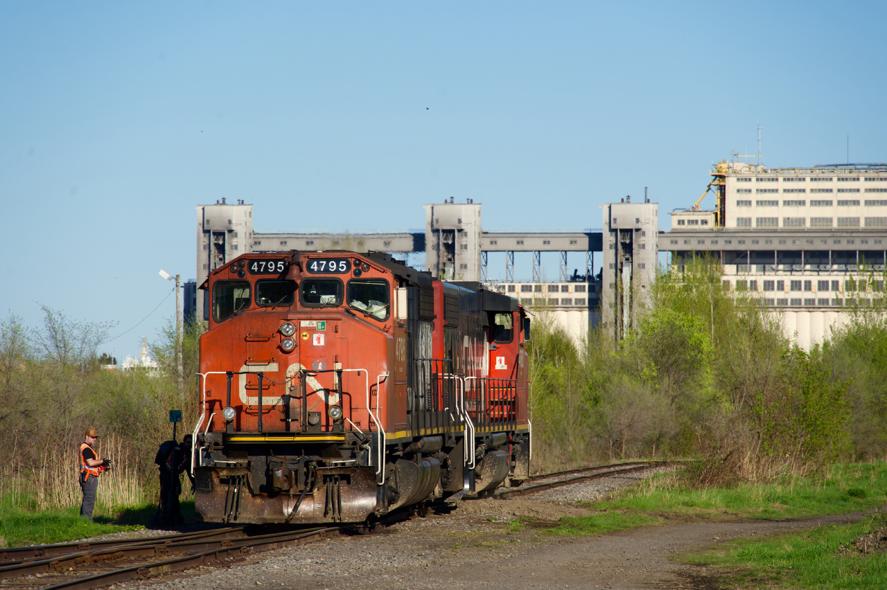 After setting off their inbound cars for a client (GETPAQ) on a nearby side track, CN YRP003-11's power has arrived light power at what was once CN's Longue Pointe Yard. They will go lift seven boxcars from the client and then spot seven more right after. This yard was used for interchange with the Port of Montreal until about 2012. While most of the tracks are still there, they have been completely covered in growth. All that's still in use is a single track that is used to reach the client. Behind is the last grain elevator still in use in Montreal (now owned by Viterra).