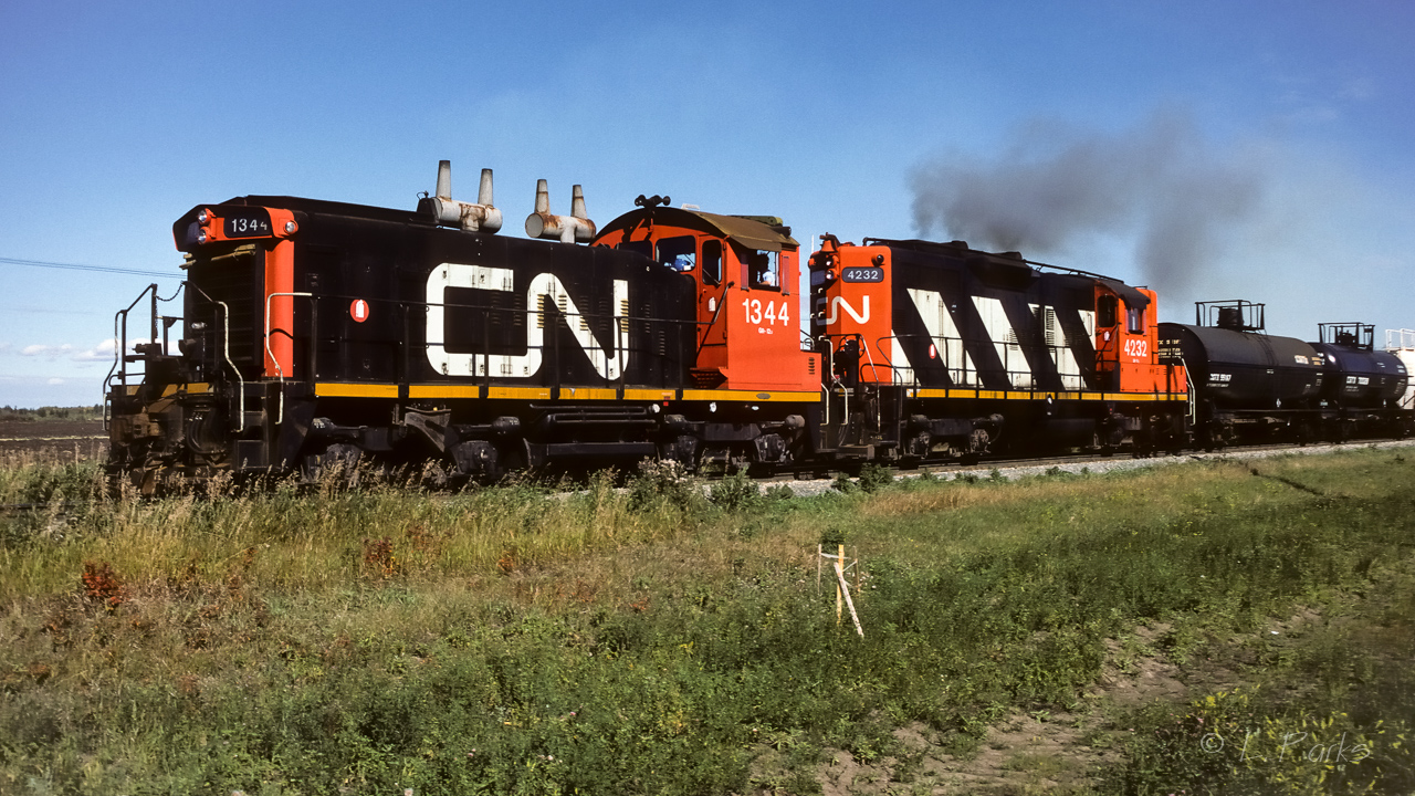 I was watching this crew for a short while as they made their train ready to go. Once they were tied on and had air, this was the result. It was full speed ahead as they left the yard. Like on the cartoons where there is a flurry of heel prints flying behind the character. I'm guessing a customer had been waiting for cars to be spotted. The train was a fair number of cars (30 to 40 range), plus a yard cab at the end. Photo taken at Scotford yard at 13:00.