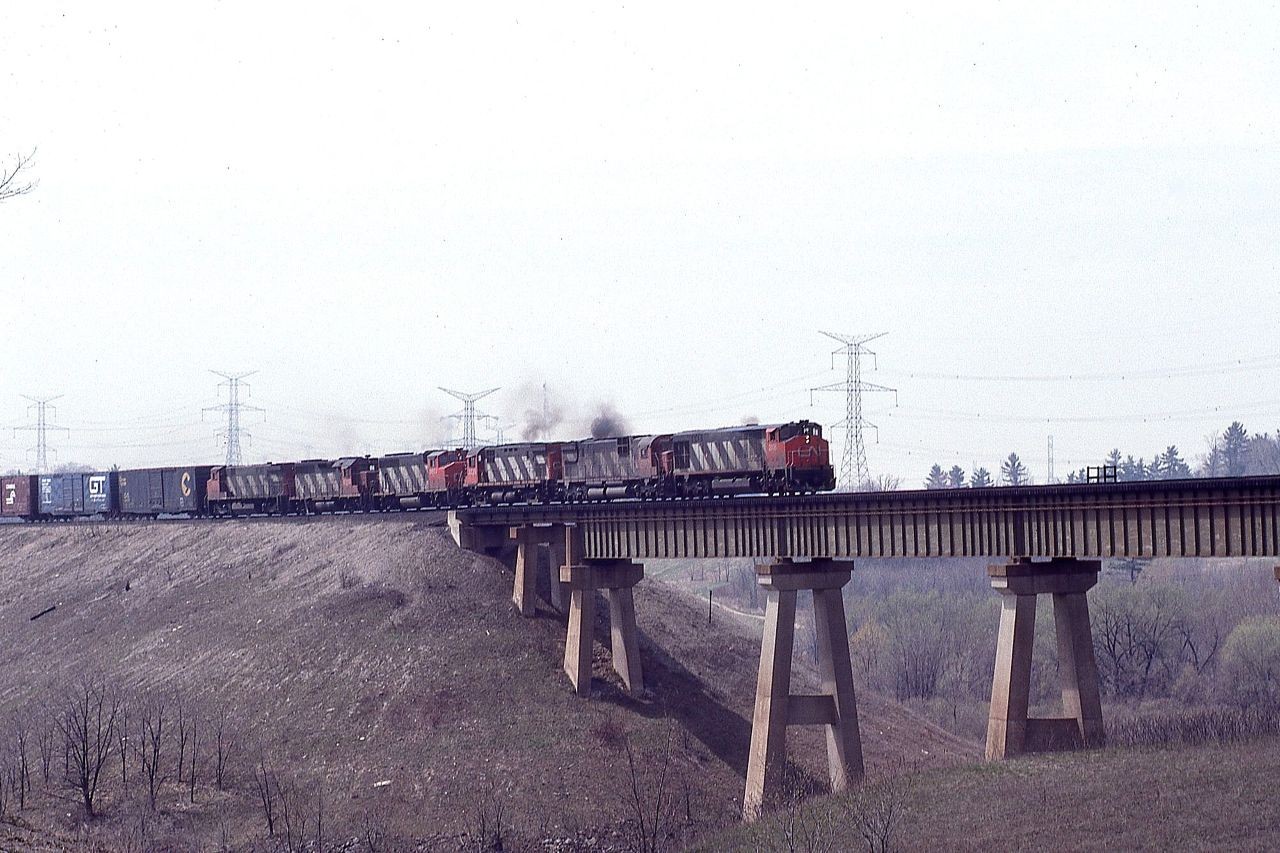 Even though the days were getting a little longer and a little warmer, winter cabin fever was still on the high side.  Despite the crappy spring day, I could not resist heading trackside.  Six units comprising six different models lead this eastbound freight over the Humber River bridge.  Units are: 2106 2003 3228 9653 9303 and 2533.  Those were the days!!!!