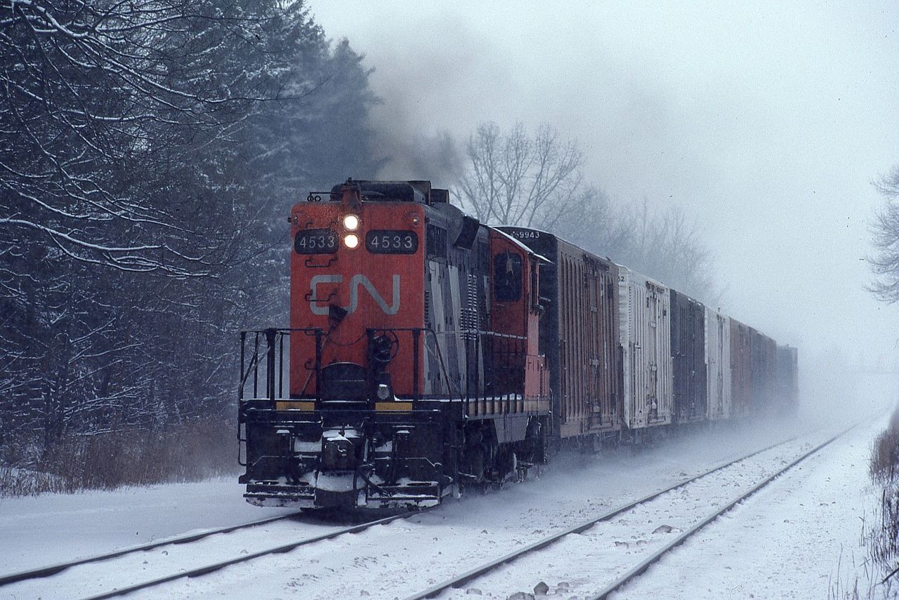 CN GP9 4533 races through Clarkson, Ontario with a short 10 car train of PFE reefers on a cold miserable January day.