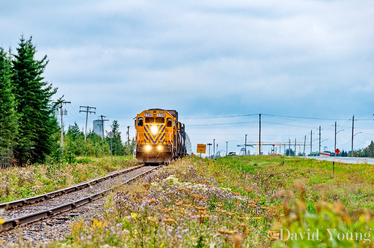 Cochrane bound- the crew of 313/ 516 leave the Hearst skyline behind. The classic water tower at left and the large crane from the local sawmill operation currently operated by Greenfirst Forest Products are the trademark sights when travelling along the Highway 11 corridor. A pair of SD40-2's power a respectable train of 33 cars out of the lumber town consisting mostly of loaded lumber, along with empty propane cars and traffic on the headend for the Kapuskasing Paper mill.