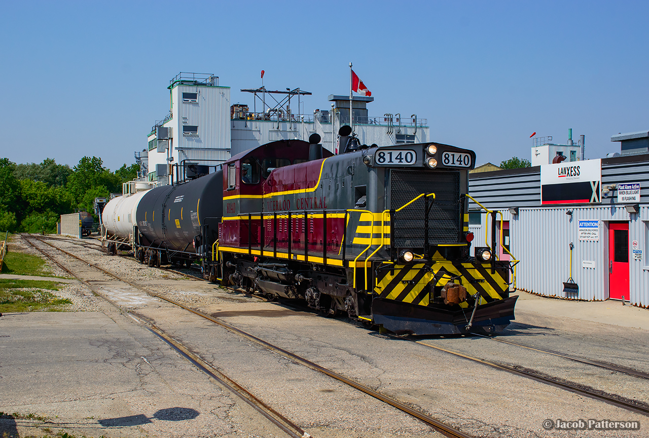 Metallic paint shining in the sun, Waterloo Central gets to work switching out tank cars at Lanxess in Elmira with leased GMD SW1200RSu 8140.
