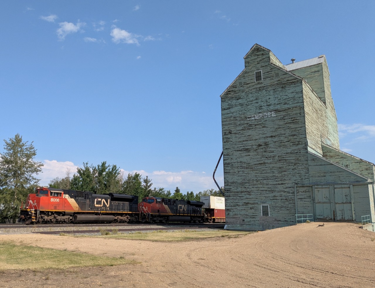 CN 8006 and CN 2316 rolling past the former Alberta Wheat Pool elevator in Camrose, Alberta.