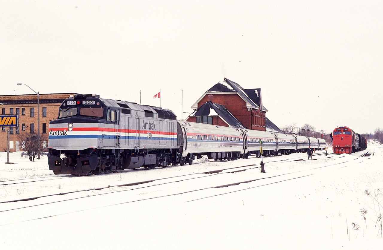 The daily NY City-bound AMTK #97 is shown stopped at the NF station on a snowy March morning. This angle I rarely shot from, and the location is filled in with foliage these days. On the right is the Pandrol Jackson grinding train with MW 109 the power unit. It would follow AMTK over the border later.