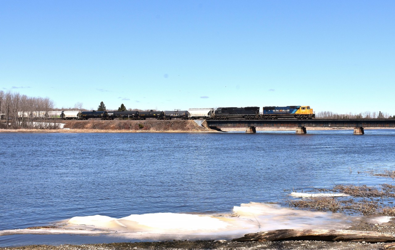 At what is a popular stop for those who are fortunate enough to show for when the #308 Englehart to Kidd train is returning, the shores of the Frederick House River provide the perfect setting.  The sun angle is great, and there are various spots along the east side of the waters for some nice images.
 You can see here that into the beginning of May there is still ice along the river. Most of it has broken up and gone downstream, but some still hugs the shoreline. While we were waiting, a few decent sized chunks floated  by. 
 What a great spot. And for anyone coming up this way, mind the bug & mosquito season and come early, mid-April to early May.
 In this scene ONR 2104 & 2124 are eastbound over the bridge around the noon hour.
