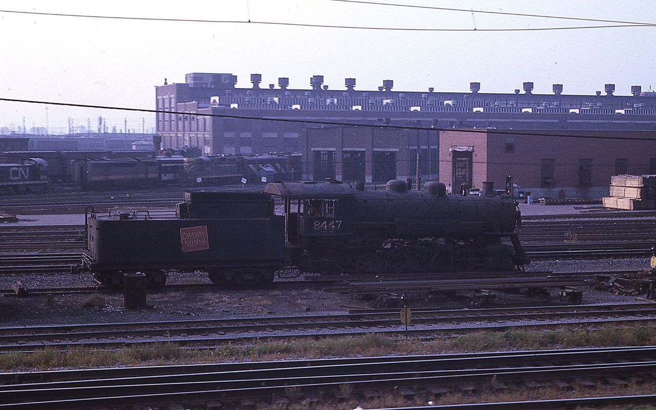 CN 0-8-0 switcher 8447 sits outside CN's Montreal Pointe St Charles Shops in September 1966.  The locomotive was built by LIMA in 1923 for the GTW as their 8222 and transferred to CN in 1957 and renumbered.  It was retired in 1960.  At the time of this photo, Capreol, Ontario mayor Harold Prescott was asking (possibly demanding) CN to donate a steam locomotive to the town for display.  Rumors at the time indicated at that CN was prepared to donate an 0-8-0 switcher.  Mr. Prescott stressed that Capreol was a "main line" railroad town and that a switcher would not be appropriate.  He continued his pursuit and eventually CN found and donated a 4-8-2 numbered 6077.  Putting this photo and the rumors together, it appears that the 8447 was set out by itself ready to head to Capreol.  Eventually the 8447 was sent to London, Ontario and scrapped.