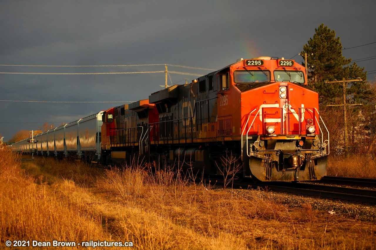 CN 875 originated at Fort Erie. Brand-new grain cars from National Steel were sent to Mac Yard. I caught them going through St. Catharines in the evening after rain showers passed through with a rainbow.