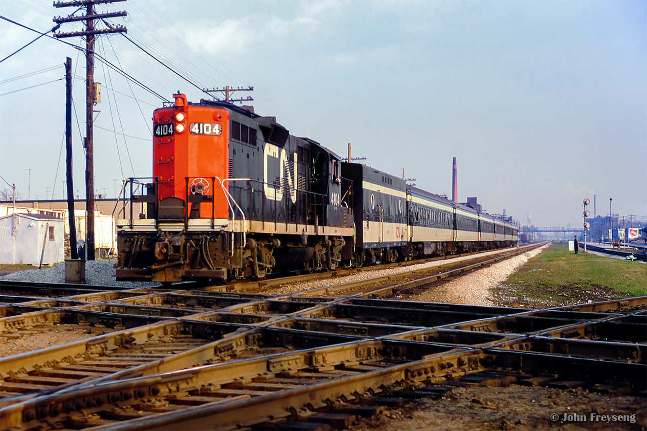 Approaching a stop at CN's West Toronto station, train 987, a local commuter train to Guelph, pounds the diamond with CP's North Toronto Sub.  Waiting just to the west of the interlocking is Budd equipped CP train 380, bound for Peterborough but detouring via CP's West Toronto station.  This move was done for about ten days on account of mudslides on the Belleville Sub Don branch near the Prince Edward Viaduct. On one occasion, there was an issue with the interlocking, and the Budds were required to use the Galt - Mactier connecting track, swinging east onto the North Toronto Sub at Osler.

Scan and editing by Jacob Patterson.