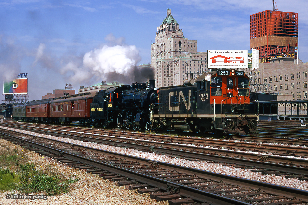 Ontario Rail Association's ex-CPR 1057 is seen eastbound by Toronto Union Station, assisted by CN GMD SW1200RS 1253.  Unusually operating over CNR trackage, the train will proceed eastbound along the Kingston Sub to Scarborough Junction, where 1057 and train will proceed up the Uxbridge Sub to Unionville, as part of the town's centennial celebration.  Assisted by 1253 as a requirement by the CNR, the switcher is thought to have been cutoff at Scarborough Jct.

Scan and editing by Jacob Patterson.