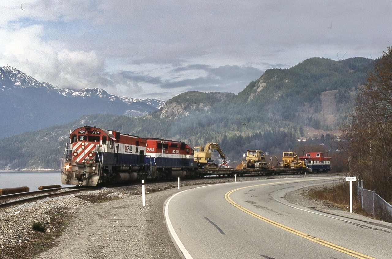 Leading a southbound work extra with one of six former Illinois central cabooses. Howe Sound is behind and Highway 99 is in the foreground.

BCOL 707 is an M-630, built by Montreal Locomotive Works in 1970 as Pacific Great Eastern 707. After retirement in 1990, it became National Railways of Mexico (FNM) 707 then Ferromex 707. BCOL 763 is an SD40-2 built by General Motors Division in 1985, retired in 2009 and current whereabouts unknown.