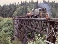 When Crown Zellerbach at Ladysmith acquired ALCo RS-3 4097 via United Railway Supply, it had been painted in a two-tone green scheme thought to be part of a sales pitch to British Columbia Railway, and was run in that livery for three months before repainted in the bright CZ orange with white stripes scheme.  This view is westbound on Wednesday 1973-08-22 with empties over the same Nanaimo River bridge in two other recent posts by me.  Please overlook that confounded water barrel platform!