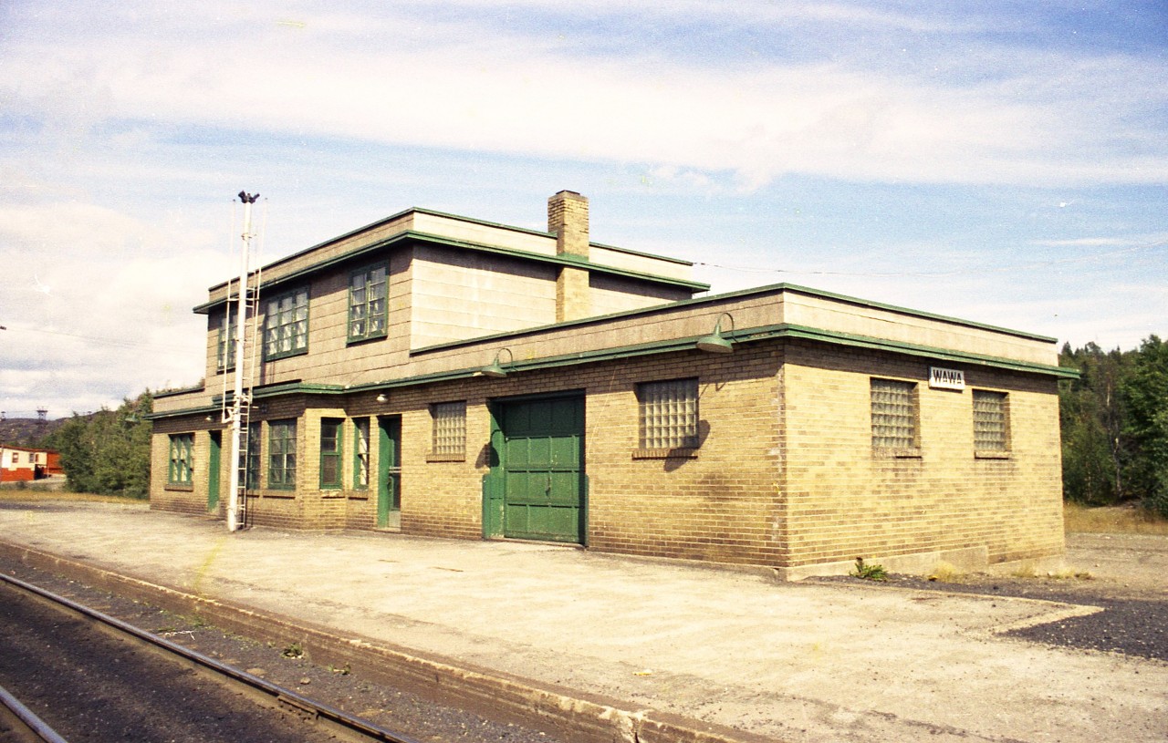 Here's an afternoon view of the old cinder block station, now closed,  just outside of Wawa.  Activity on the line here when the mines and smelter closed up in late 1997 and abandoned not long after. I'm not sure when the station was demolished but am guessing around early 1980s.The Michipicoten Sub is now in the history books, as is all the mining activity that once kept Wawa a vibrant community. The town has slipped from 4800 people down to about 2600, but fishing and hunting as well as a tourist stop along the Trans-Canada keep the town alive.
Even the rail station at Hawk junction where this branch met with the old AC mainline is now boarded up.  Along the Mic branch, Hawk Jct was mile 0, end of line at Michipicoten Harbor was mile 26, and the old station at 18.6.