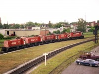 A 5 unit CP power move heading westbound over the Galt sub on a hazy late spring morning. The scene is by the old West Toronto diamond, just out of sight on the left.  Interesting collection of oldies: Three ALCO S-2 units 7029, 7060, 7043 lead SW1200RS 8146 and last, looking rather impressive against the others, MLW RS-18 8768.The S-2s were gone from the roster by 1986.