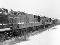 It is a cloudy November 30, 1968 in London, Ontario. At the CN Reclamation Yard, CLC road switchers, ALCO or MLW road switchers, and CLC C-Liners are visible. Some seem to be complete locomotives while others are just rusting hulks.