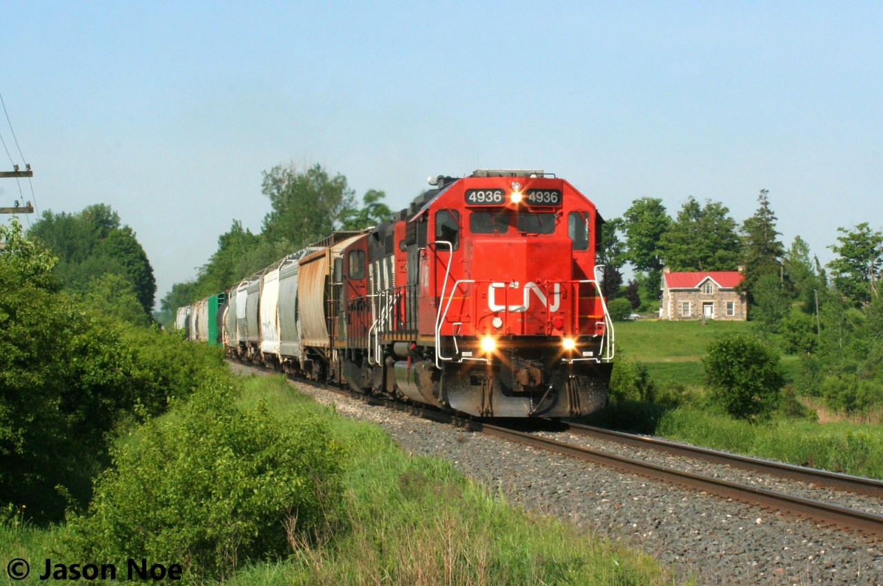 CN L542 with 4936 and 4131 are viewed approaching the Woolwich-Guelph Townline crossing on the Guelph Subdivision, situated east of Kitchener, as it heads for XV yard in Guelph. Later that morning, L542 would traverse the Fergus Spur to Cambridge with one loaded bulkhead car for Gillies Lumber.