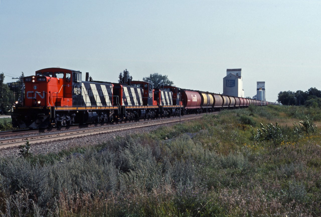 GMD1u 1612 leads sisters 1600 and 1601 west over the Rivers sub with a train of covered hoppers for loading at country elevators. Unfortunately, Oakville's elevators and the GMD1s as well as most of the "Trudeau hoppers" are now gone...