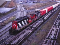 A transfer from the Port of Montreal arrives at MonTerm, on the site of CN's old Turcot Yard (which was the major yard in Montreal until Montreal Yard--now known as Taschereau Yard--opened in September 1961). Turcot subsequently became a piggyback and container terminal until September 2002 when intermodal operations where moved to the newly constructed Montreal Intermodal Terminal at the reconfigured Taschereau Yard (the hump having been shut down). Today, Turcot continues to act as a crew change point for through trains bypassing Taschereau. Back to that transfer with GP9s 4424 and 4416--note that the latter unit has some GP7 battery box louvres and still has an "oil can" headlight, which early GP9s were delivered with. And, for those of you who have always wondered where the "Dofasco steel containers" went after leaving Hamilton, the Montreal unloading facility is in the background (hence the placement of the container flats at the rear/west end of Hamilton-Montreal train 252).