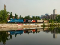 CN 500 is reflected in the Lachine Canal as it leaves Ardent Mill with seven grain empties.