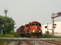 CN YRP003 has a GP9 first and third as it heads towards client getpaq in East End Montreal on a smokey evening.