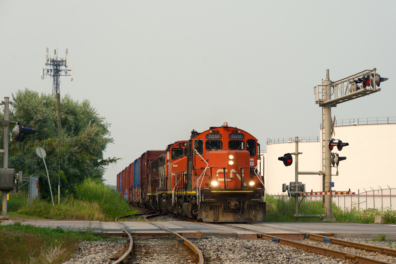 CN YRP003 has a GP9 first and third as it heads towards client getpaq in East End Montreal on a smokey evening.